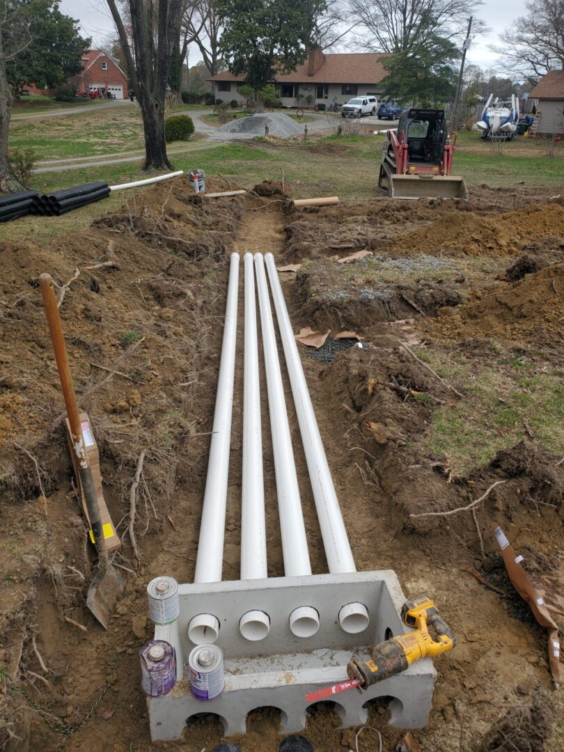 A pipe laying in the ground with other pipes.